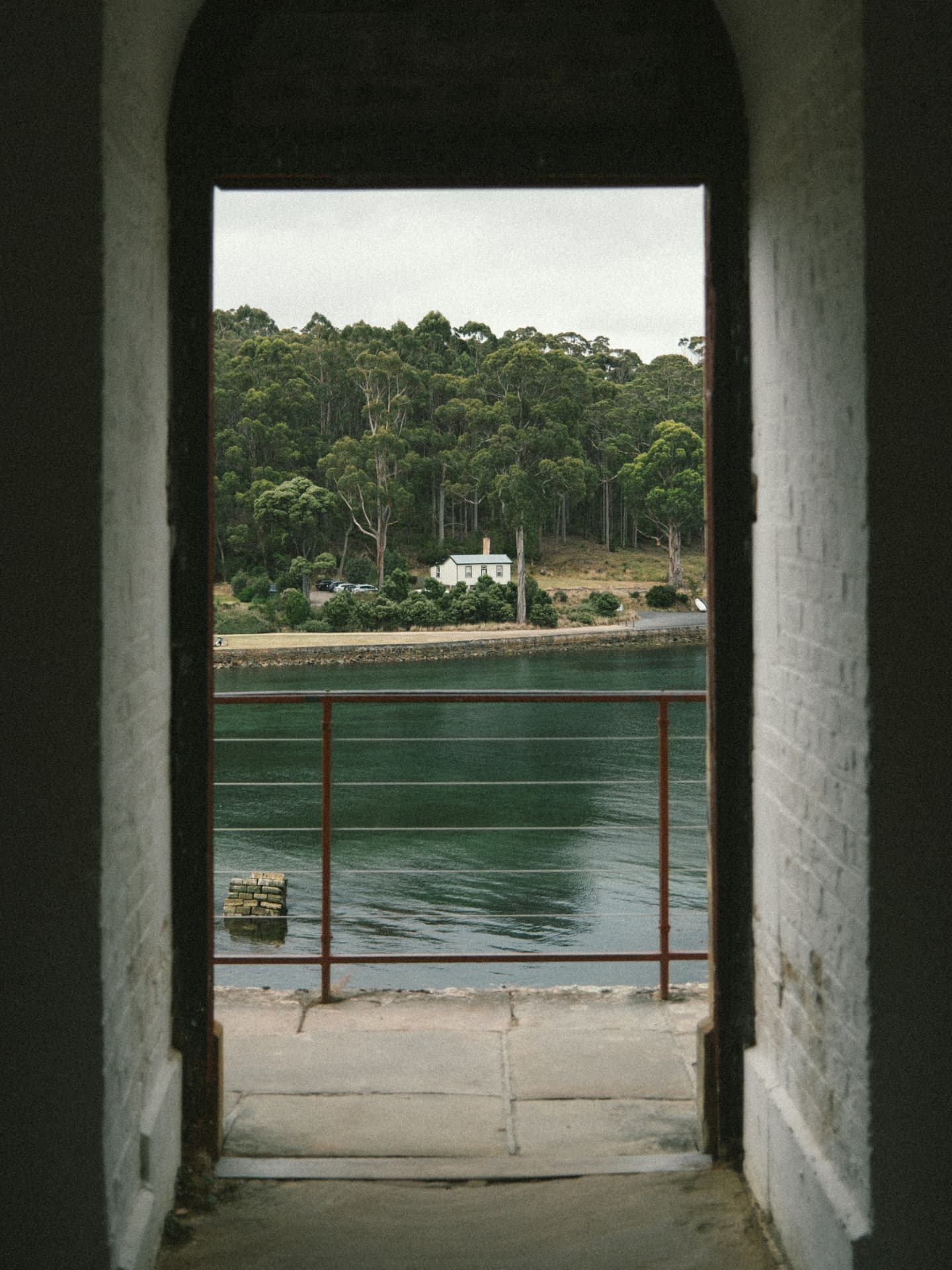 A whitewashed Port Arthur doorway framing a cottage and sheltered water